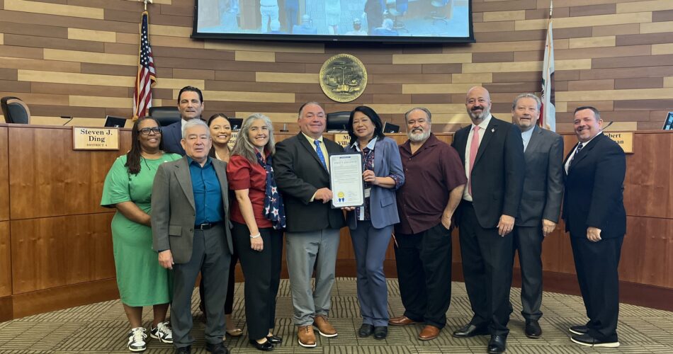 A group of leaders standing in a courtroom holding the Binational Health Coalition