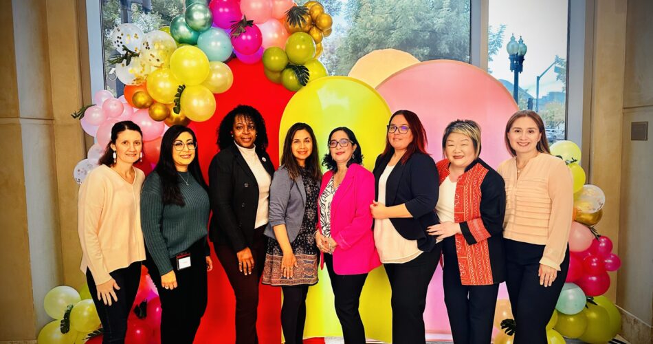 Women standing in front of balloons celebrating an event at Health Plan of San Joaquin.