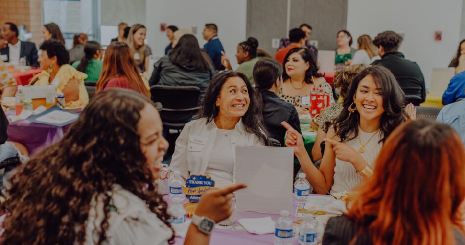 Volunteers from the VITA program at a celebratory dinner laughing and conversing.