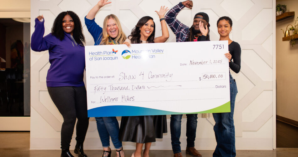 A group of 5 people from Shaw 4 Community receiving a 50 thousand dollar check for Wellness Hikes.