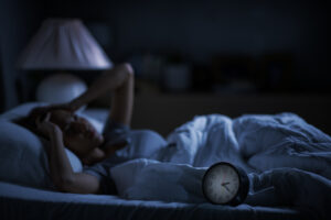 Depressed young woman lying in bed cannot sleep from insomnia A woman having difficulty sleeping due to insomnia prompted by depression.